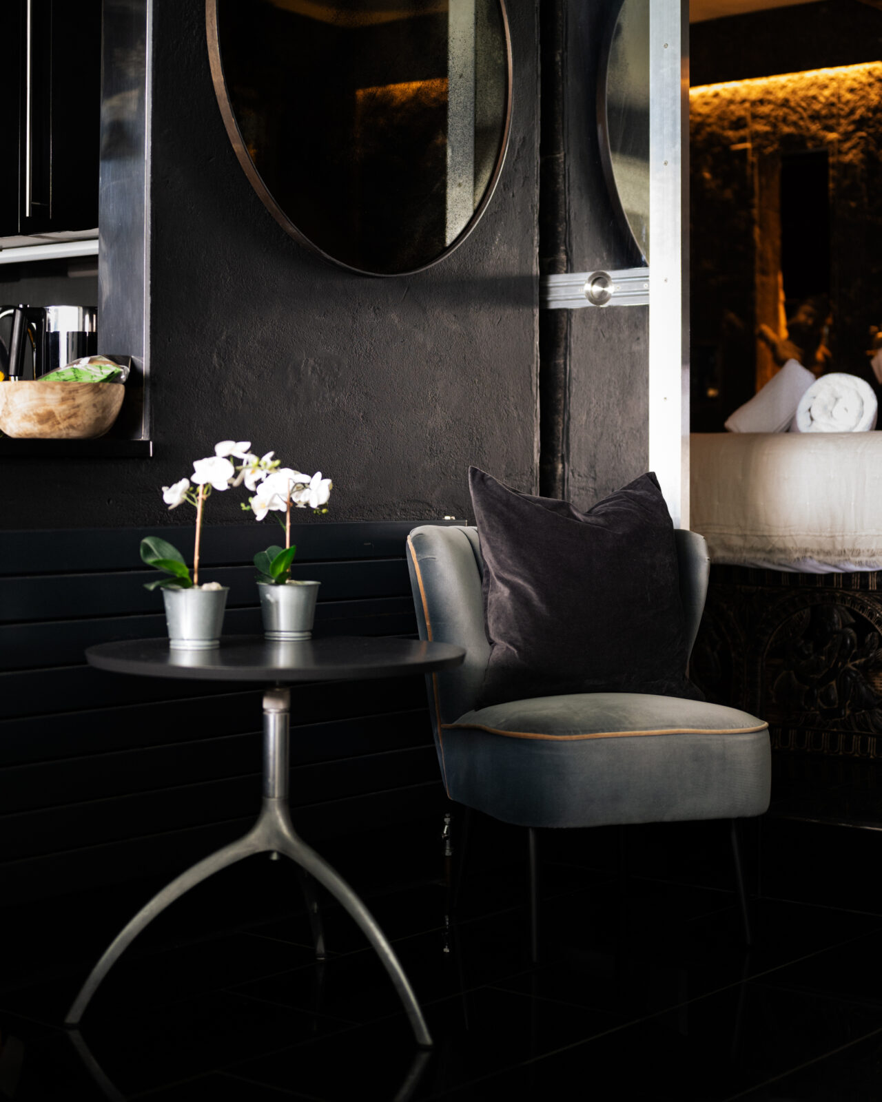 flowers on a table nect to a velour chair