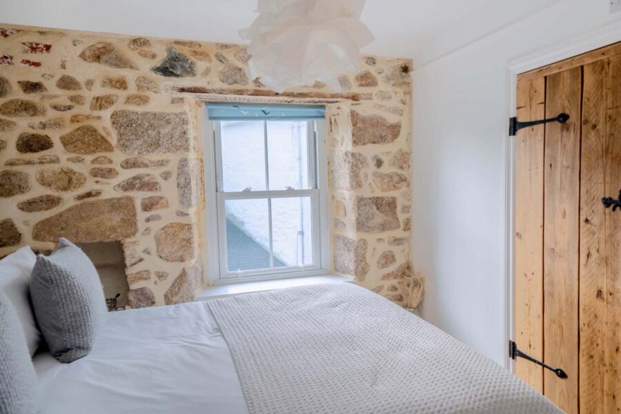 Bedroom with wooden doors and exposed stone walls