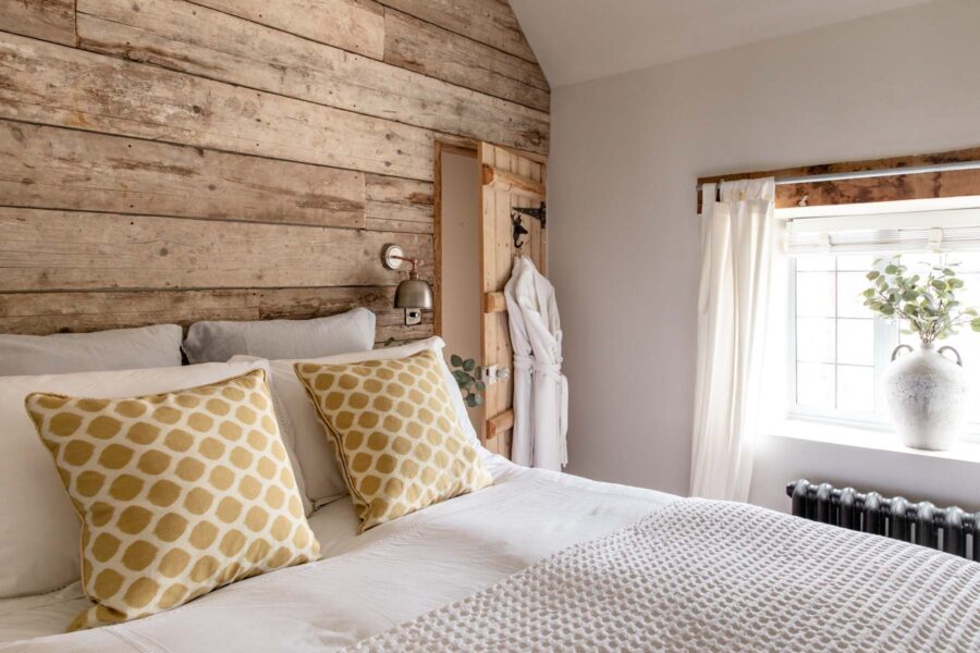 Smartly decorated bed with yellow cushions