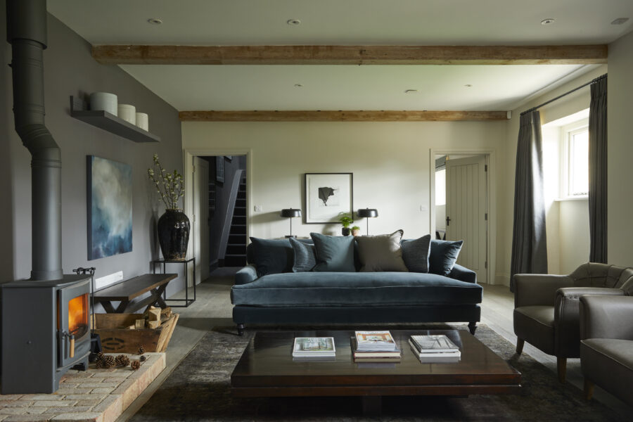 Blue sofas with magazines on wooden coffee table and log burner