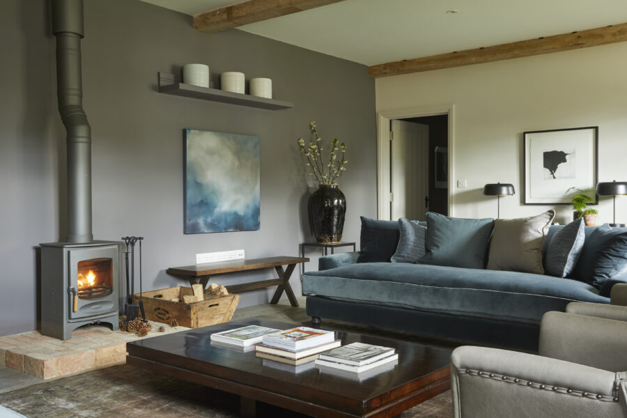 Blue sofas with magazines on wooden coffee table and log burner