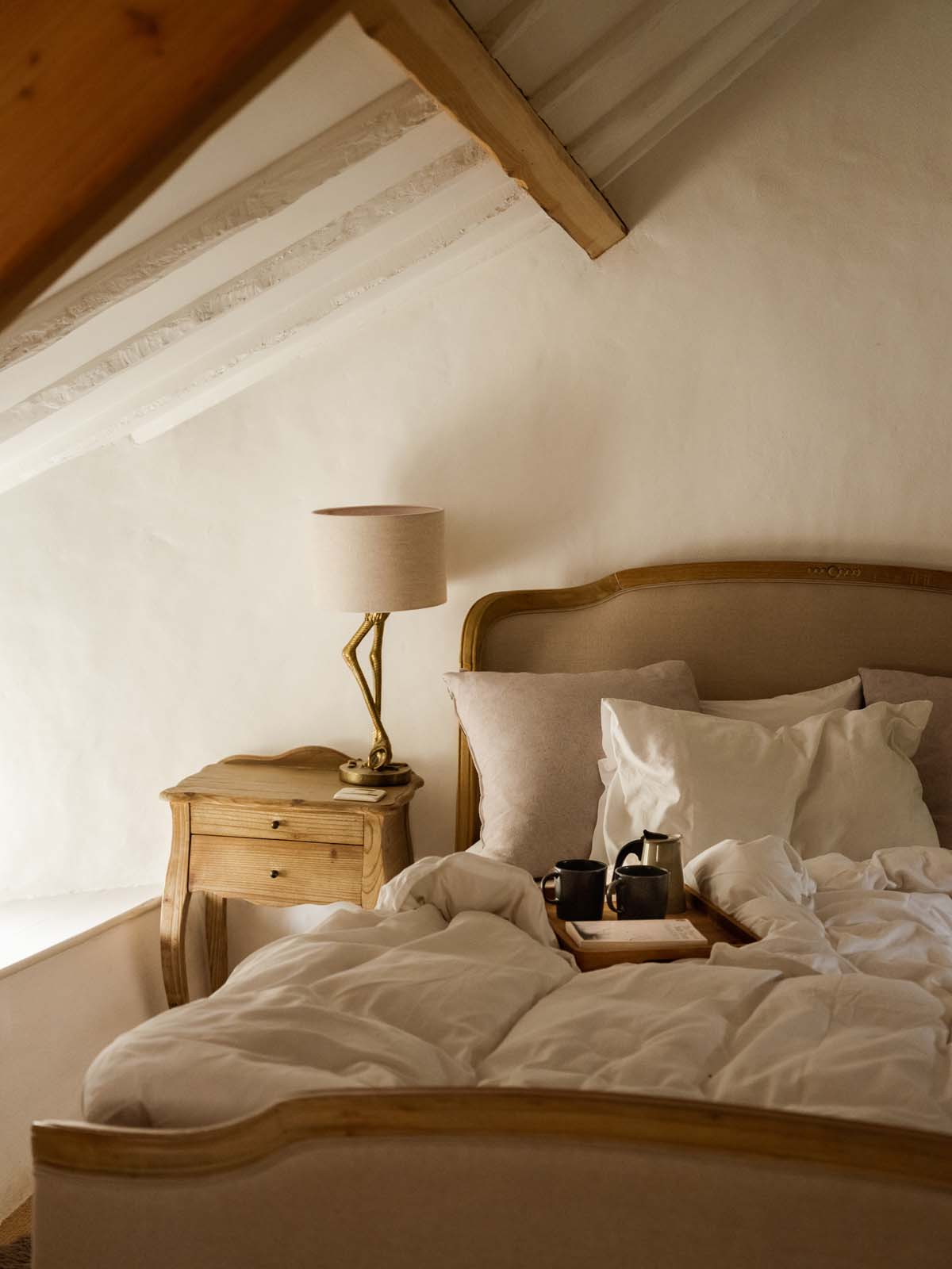 Cosy cottage master bedroom with cups of tea