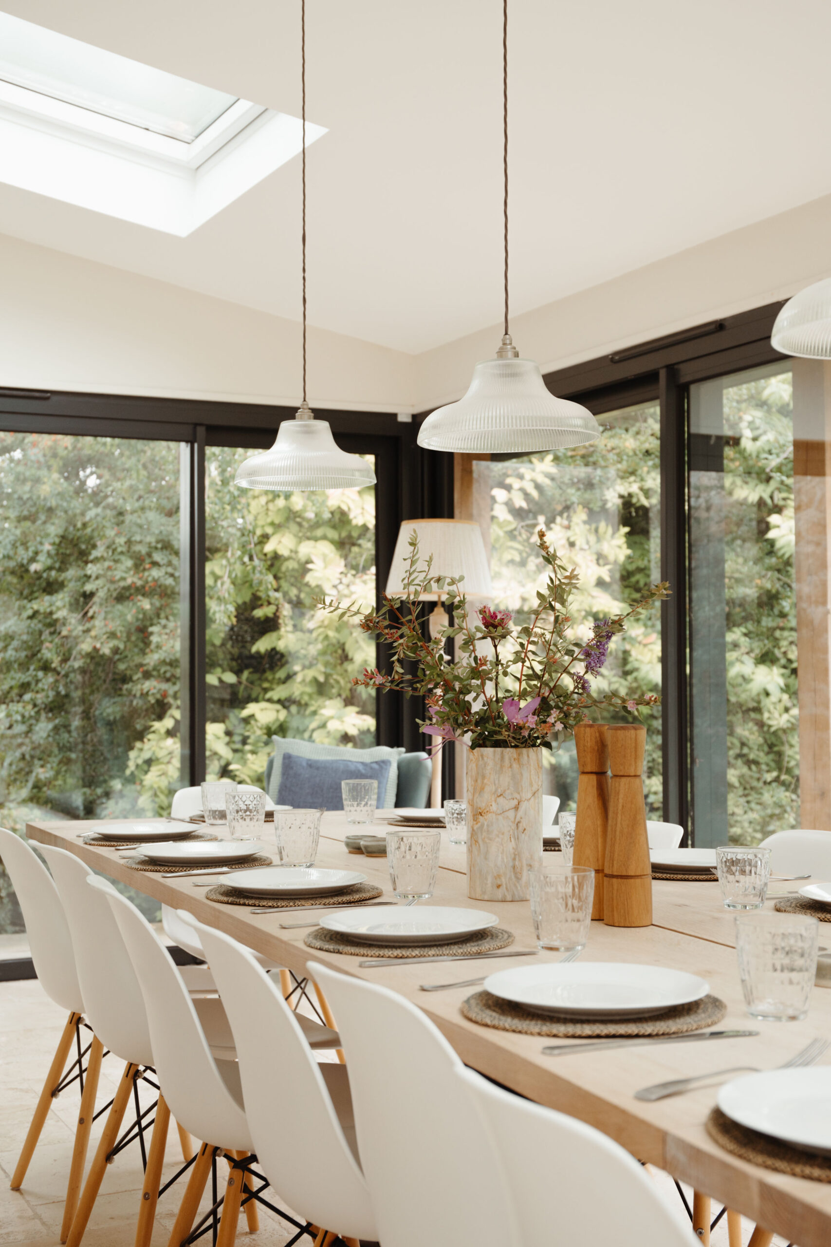 Large dining table laid with glasses, plates and flowers