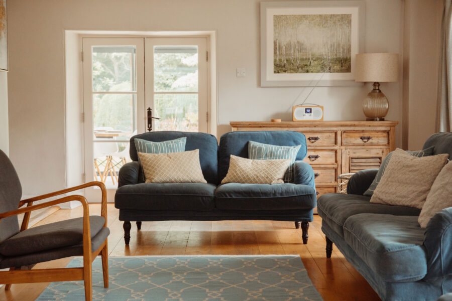 Sitting room with two blue sofas and a modern armchair