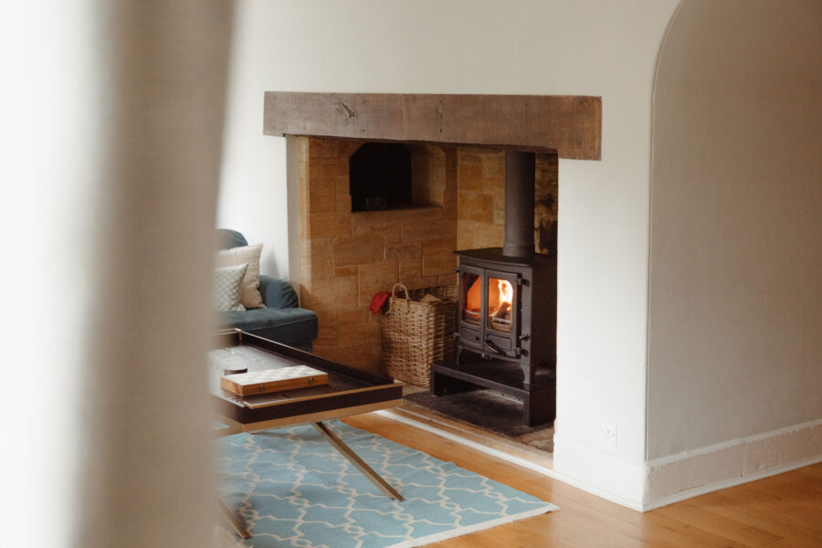 Room with wood burning stove in a large old fireplace