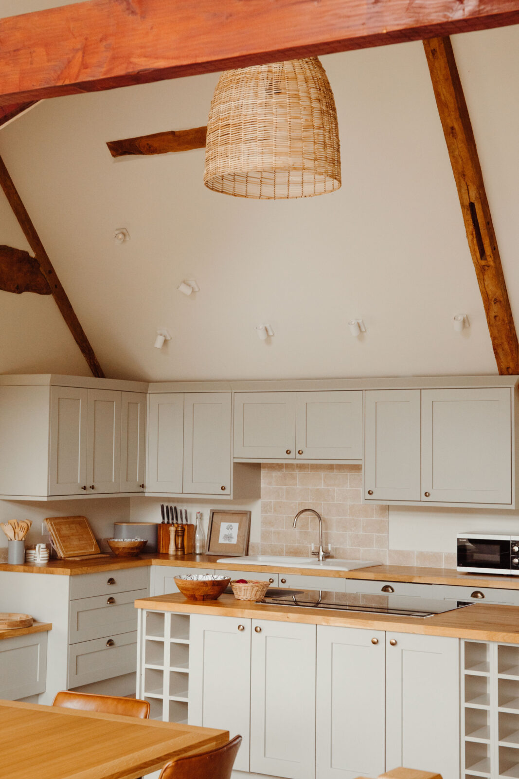 A wicker lampshade hanging in a country house kitchen
