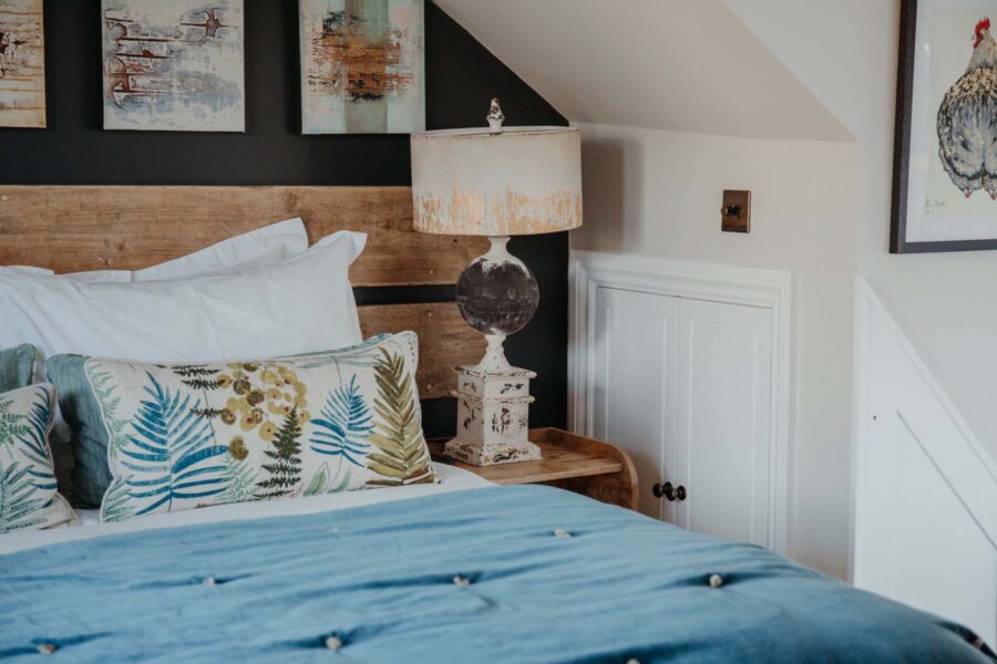Bed with blue velvet throw and patterned cushions