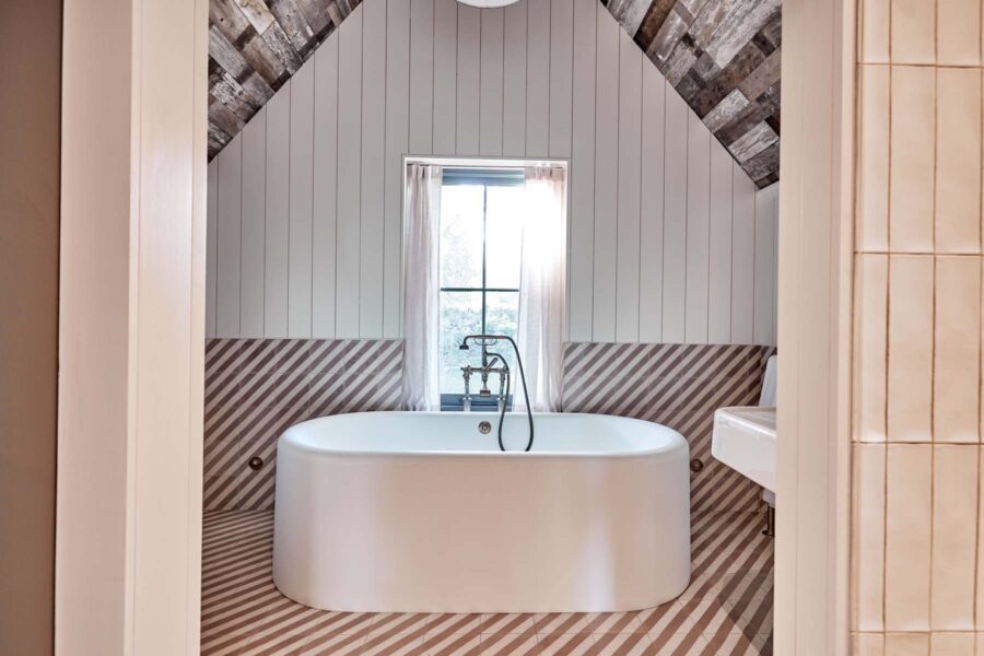 Large standalone bathtub with vaulted bathroom ceiling