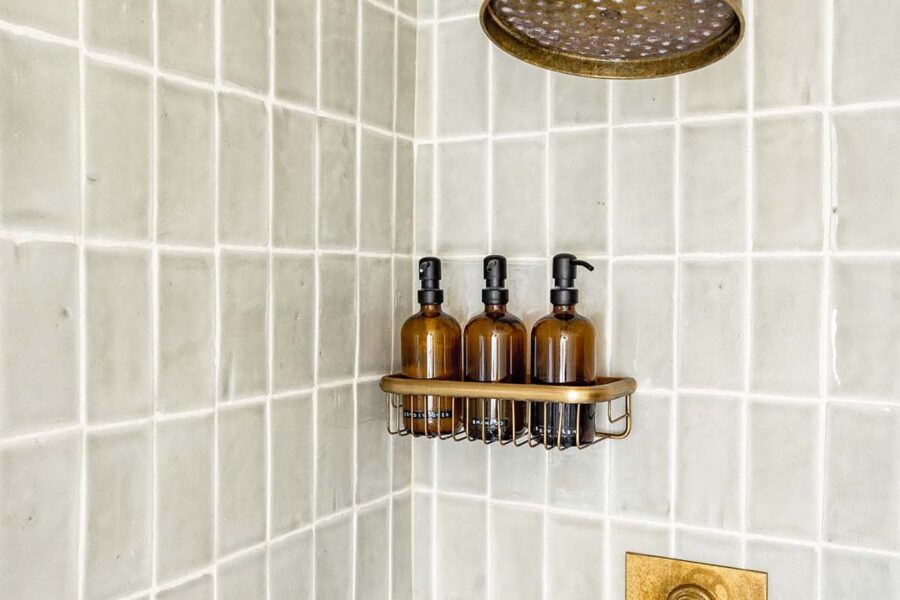 Shower with neutral grey tiles and brass shower head
