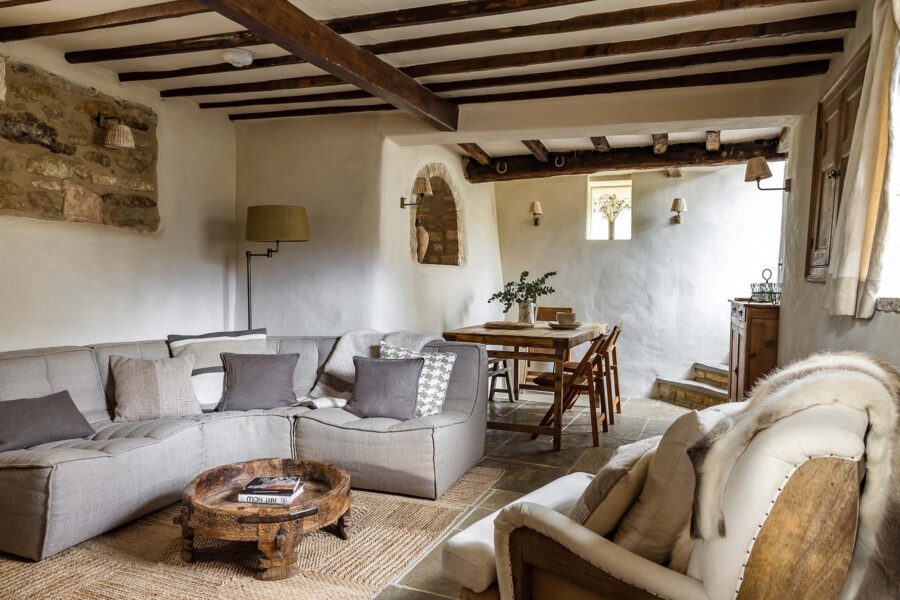 Cosy cottage living and dining room with exposed beams and rustic modern furnishings