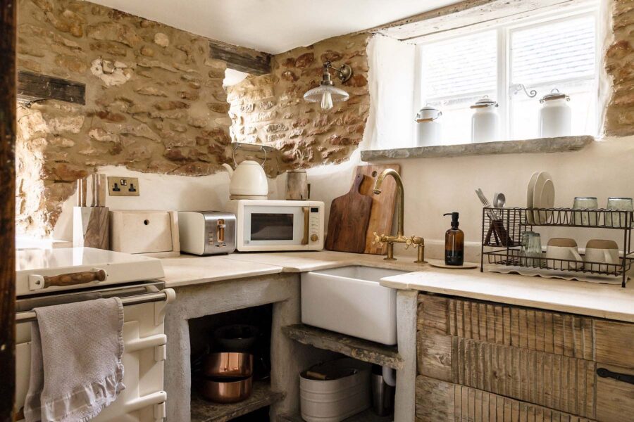 Corner of a quaint cottage kitchen with exposed stone walls