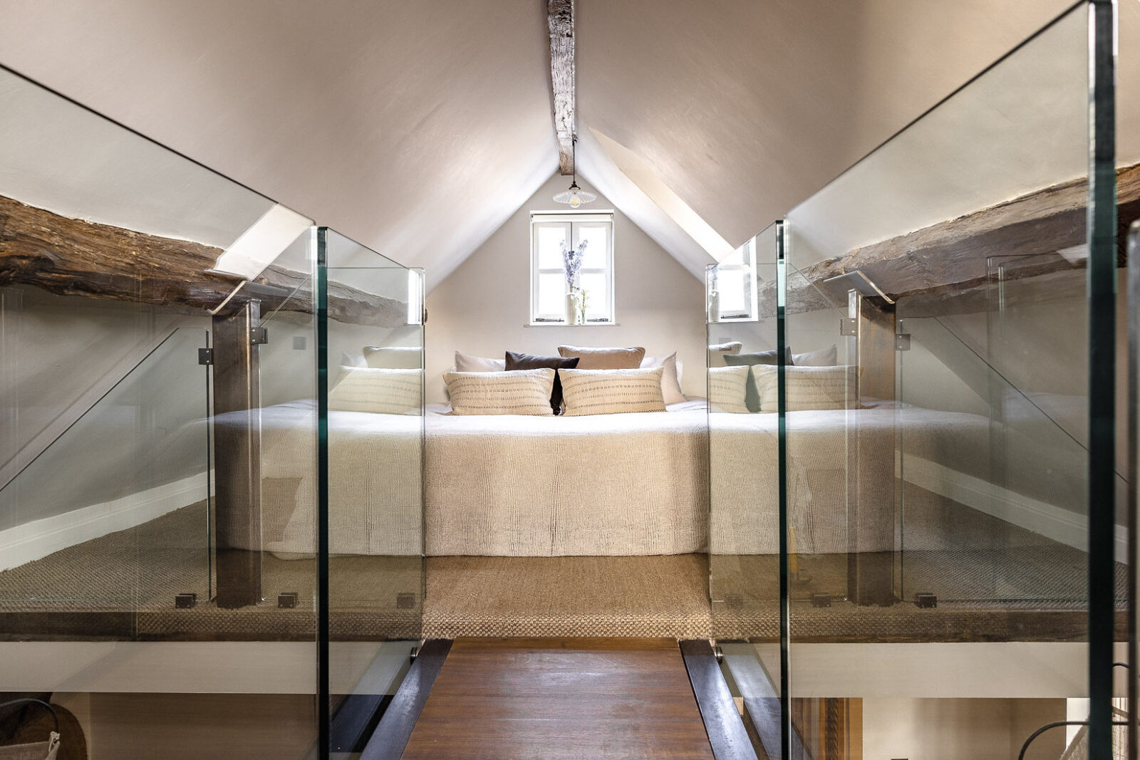 A glass bridge leading up to the mezzanine bedroom