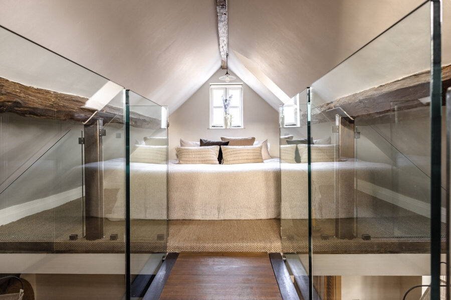 A glass bridge leading up to the mezzanine bedroom