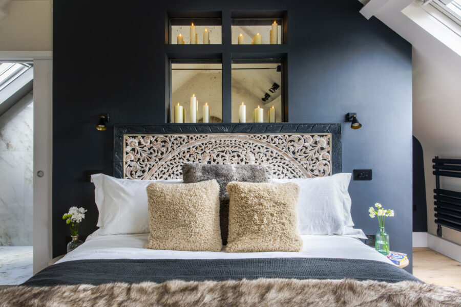 Close up of a luxurious bohemian bed with an ornate carved headboard